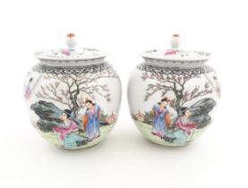 A pair of Chinese pot and cover vases decorated with ladies in a landscapes, and Character script.