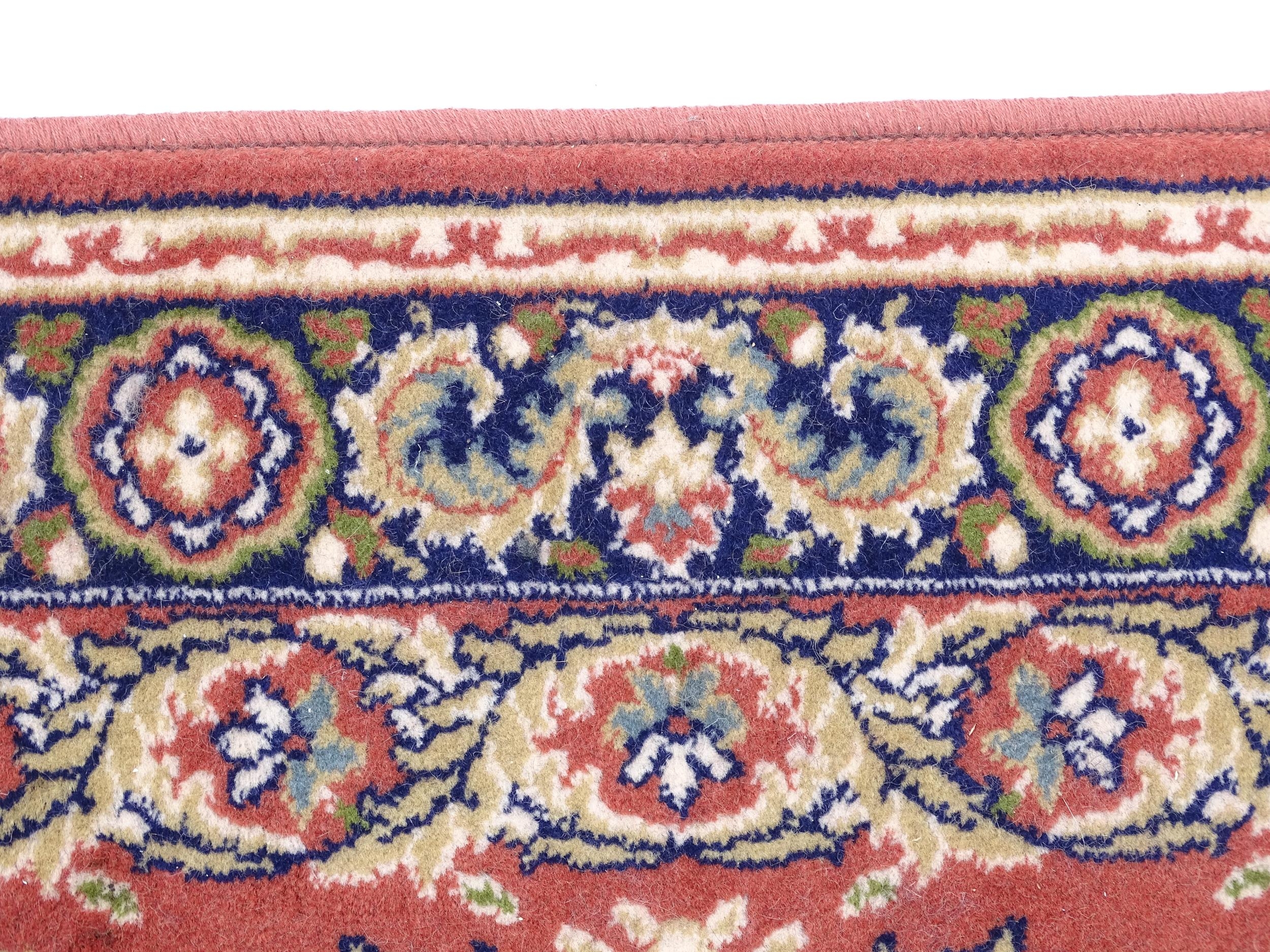 Carpet / Rug : A red ground rug with central floral motif, bordered by floral and foliate scroll - Image 7 of 7