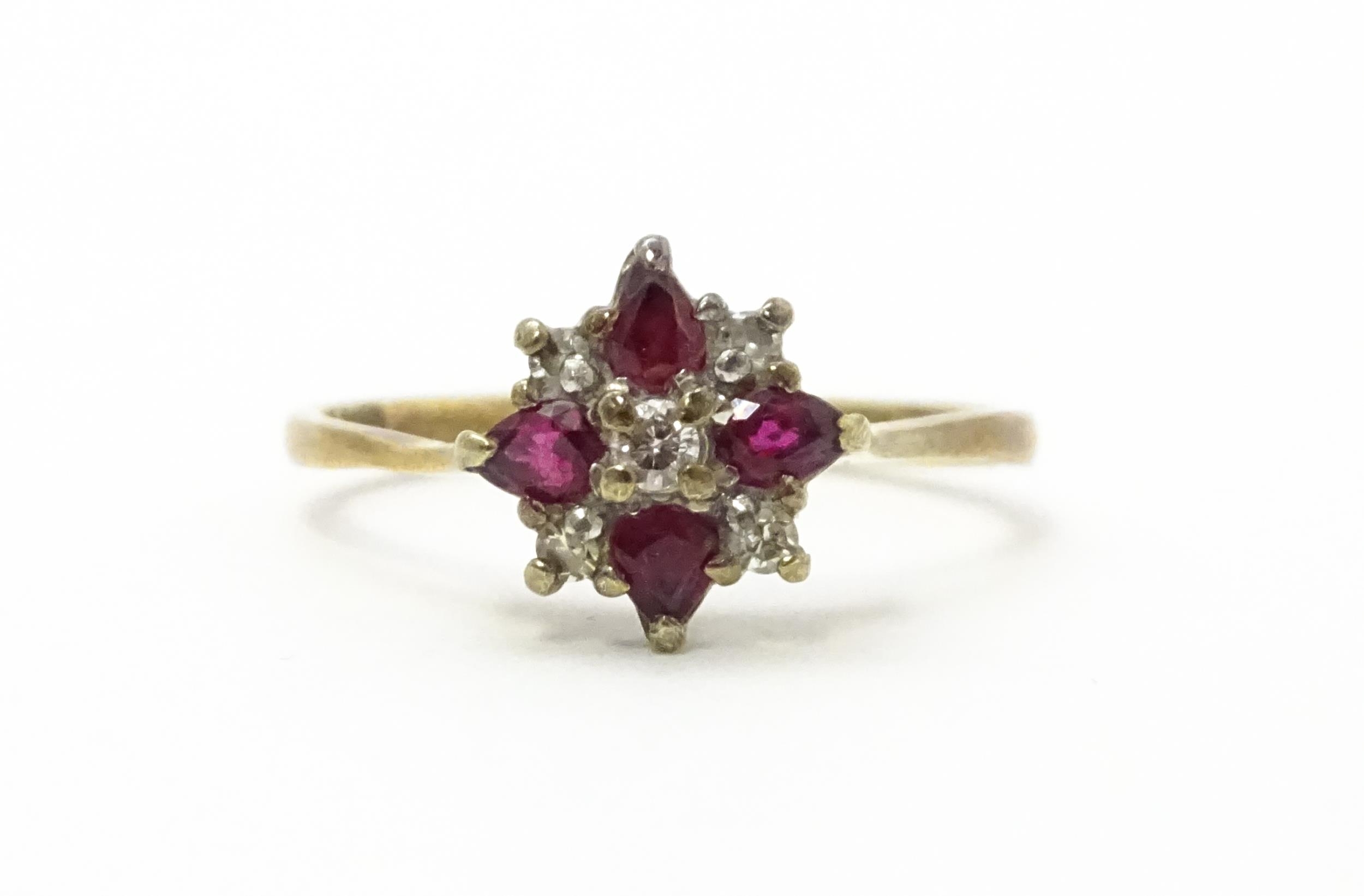A 9ct gold ring set with diamonds and red stones. Ring size approx. M 1/2 Please Note - we do not