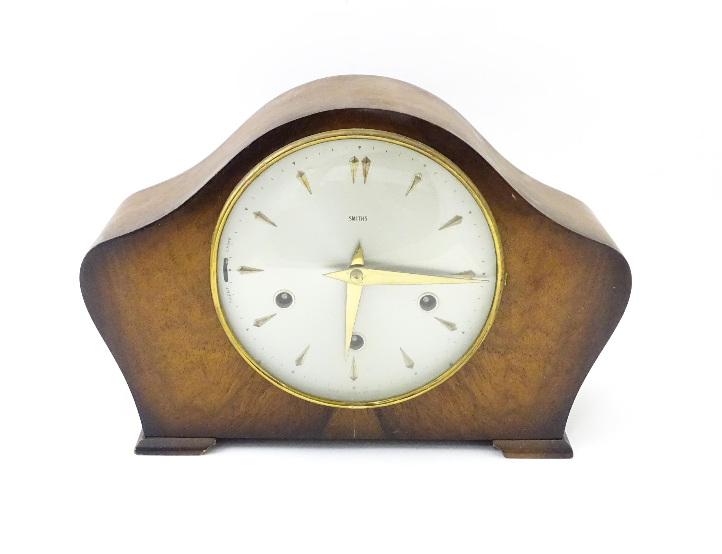 A 20thC smiths walnut cased mantle clock with chiming movement. Approx. 8" high Please Note - we