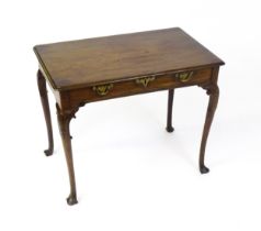 A George III mahogany side table with a moulded top above a single long frieze rawer with brass