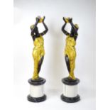 A pair of large cast bronze female blackamoor torcheres with gilt detail, raised on marble