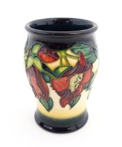 A Moorcroft vase of barrel form decorated in the Kapok Tree. Marked and signed under. Approx. 5 1/2"