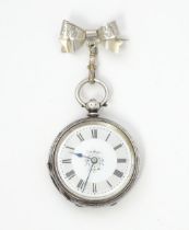 A ladies pocket watch with bow formed brooch hanger. The brooch hallmarked Chester 1908 maker S Ward