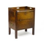 An 18thC mahogany commode with an upstand having three pierced handles, the front having a hinged