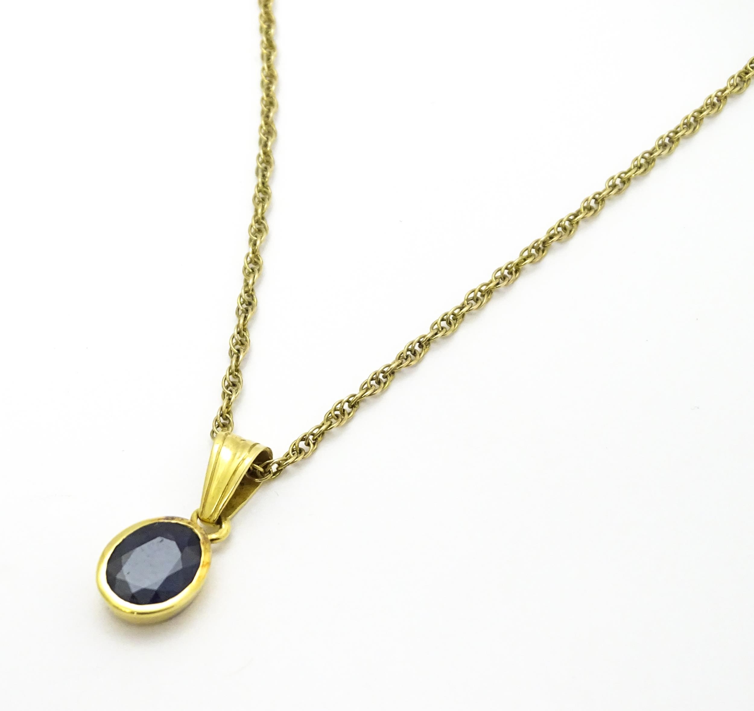 A yellow metal pendant set with central sapphire on a 9ct gold chain. Pendant approx. 1 3/4" long - Image 3 of 6