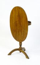 An early 20thC New England style occasional table, with an oval planked top, a storage compartment