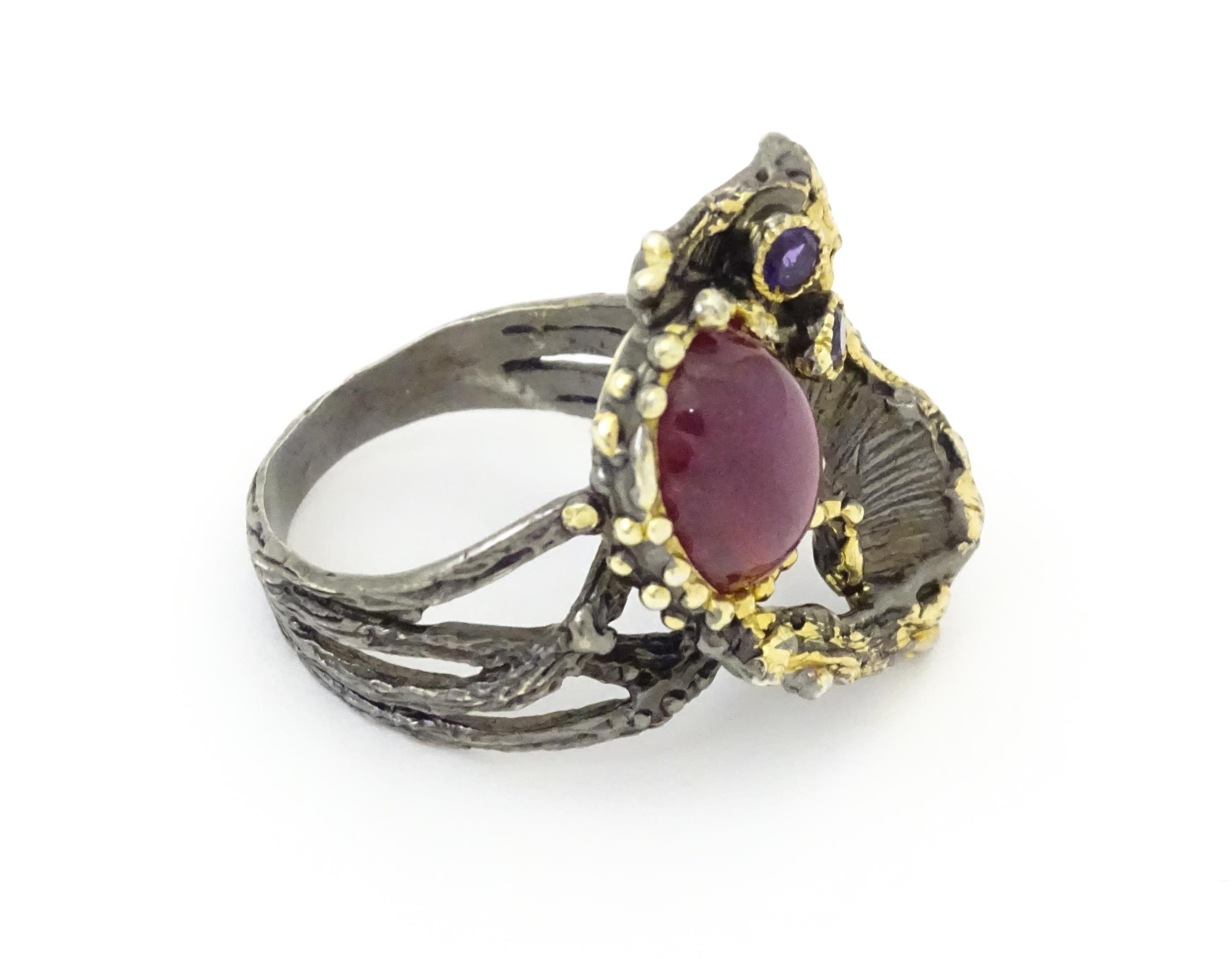A silver ring set with ruby cabochon and two amethysts, with gilt highlights. Ring size approx. O - Image 3 of 5