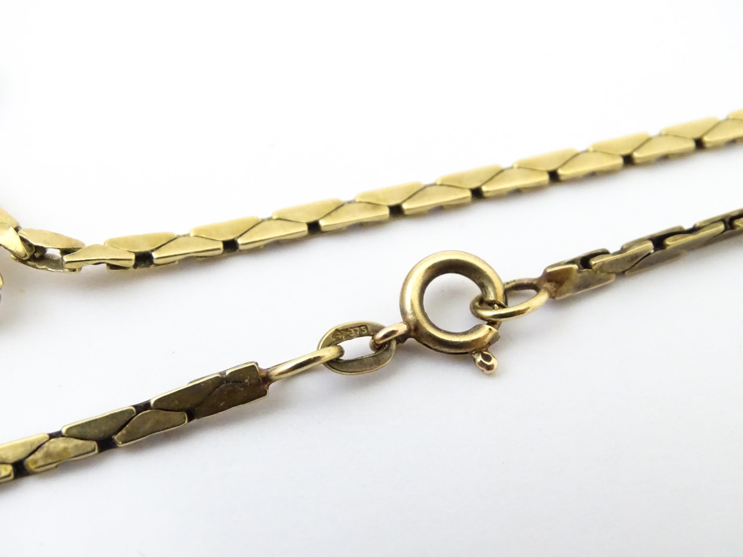 A 9ct gold necklace with textured oval detail to lower section. Bearing import marks for London - Image 9 of 10