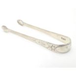 Geo III silver sugar tongs with bright cut decoration. Hallmarked London 1791. Approx. 5” long.