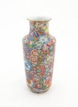 A Chinese famille rose vase decorated with a profusion of flowers. Character marks under. Approx. 10