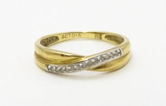 A 9ct gold ring set with diamonds in a crossover setting. Ring size approx. J Please Note - we do