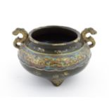 A small Chinese censer with twin handles with banded decoration in relief depicting stylised dragons