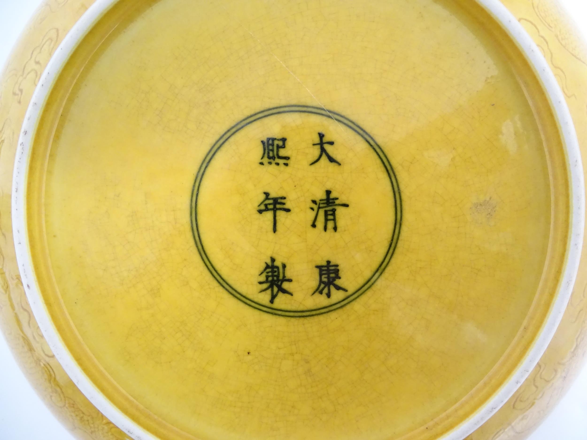 A Chinese dish with a yellow ground decorated with dragons amongst stylised clouds. Character - Image 2 of 4