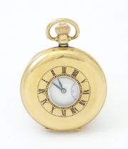 A 9ct gold half hunter pocket watch. The side wind watch with white enamel dial having Roman