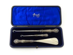 A cased silver handled shoe horn and two button hooks hallmarked Birmingham 1901. Case approx. 9"