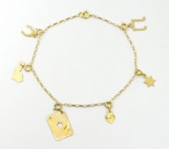 A 9ct gold bracelet set with various charms to include horse shoe, ace of spades, rabbit, etc.