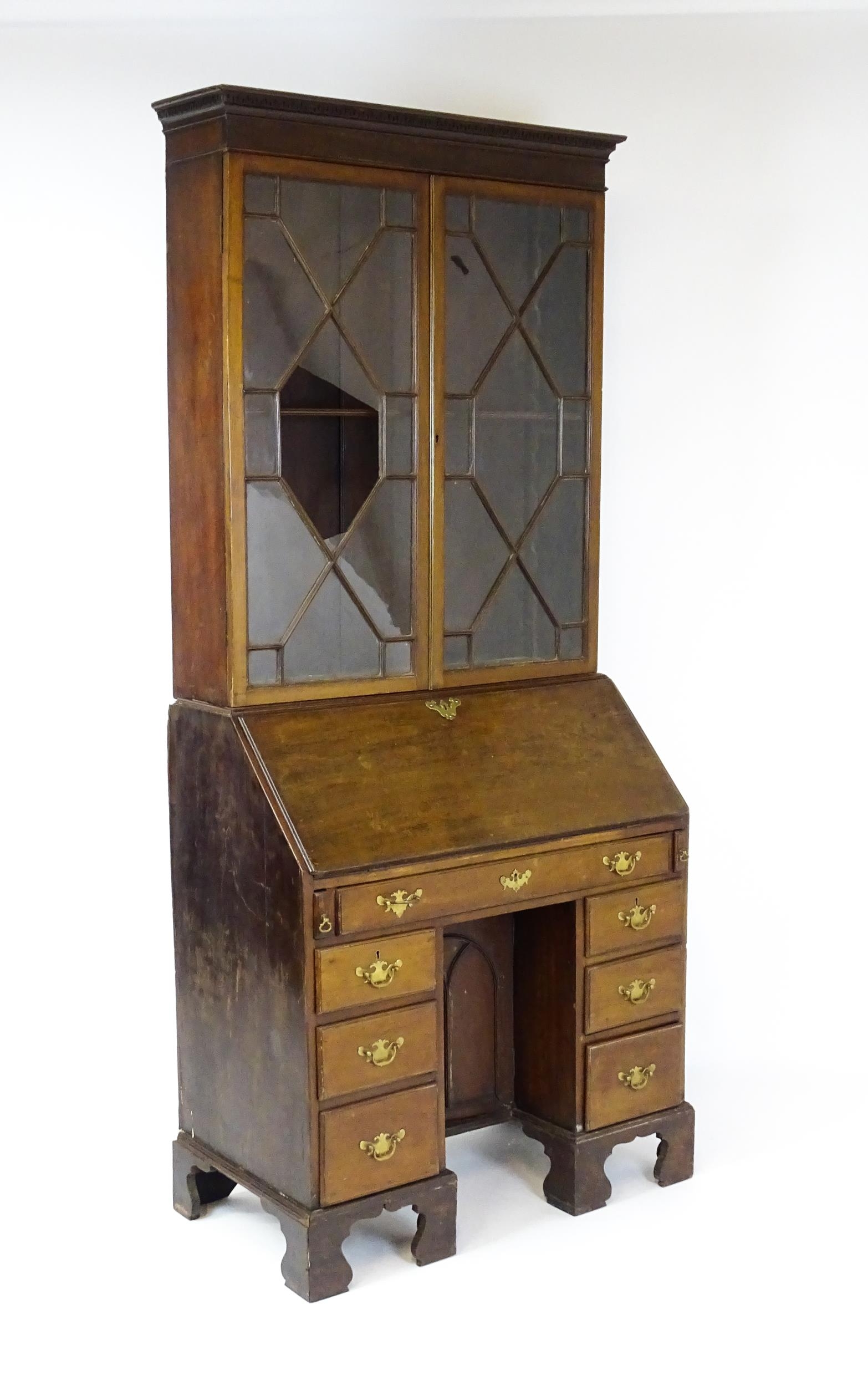 A Georgian mahogany bureau bookcase, with a moulded top above two astragal glazed doors and a fall