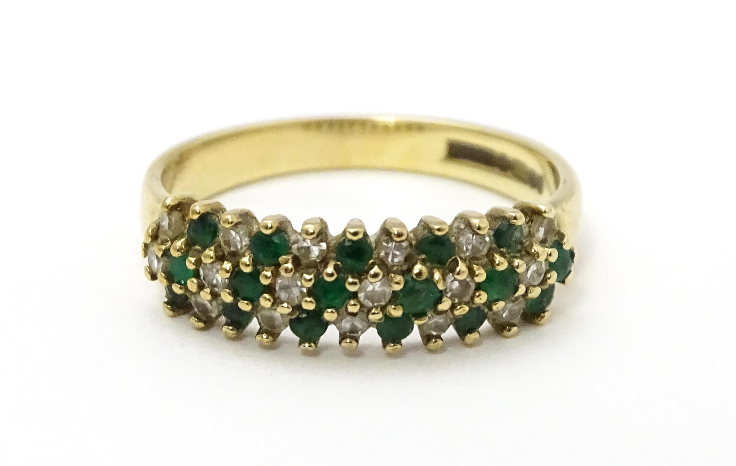 A 9ct gold ring set with emeralds and diamonds. Ring size approx. K Please Note - we do not make