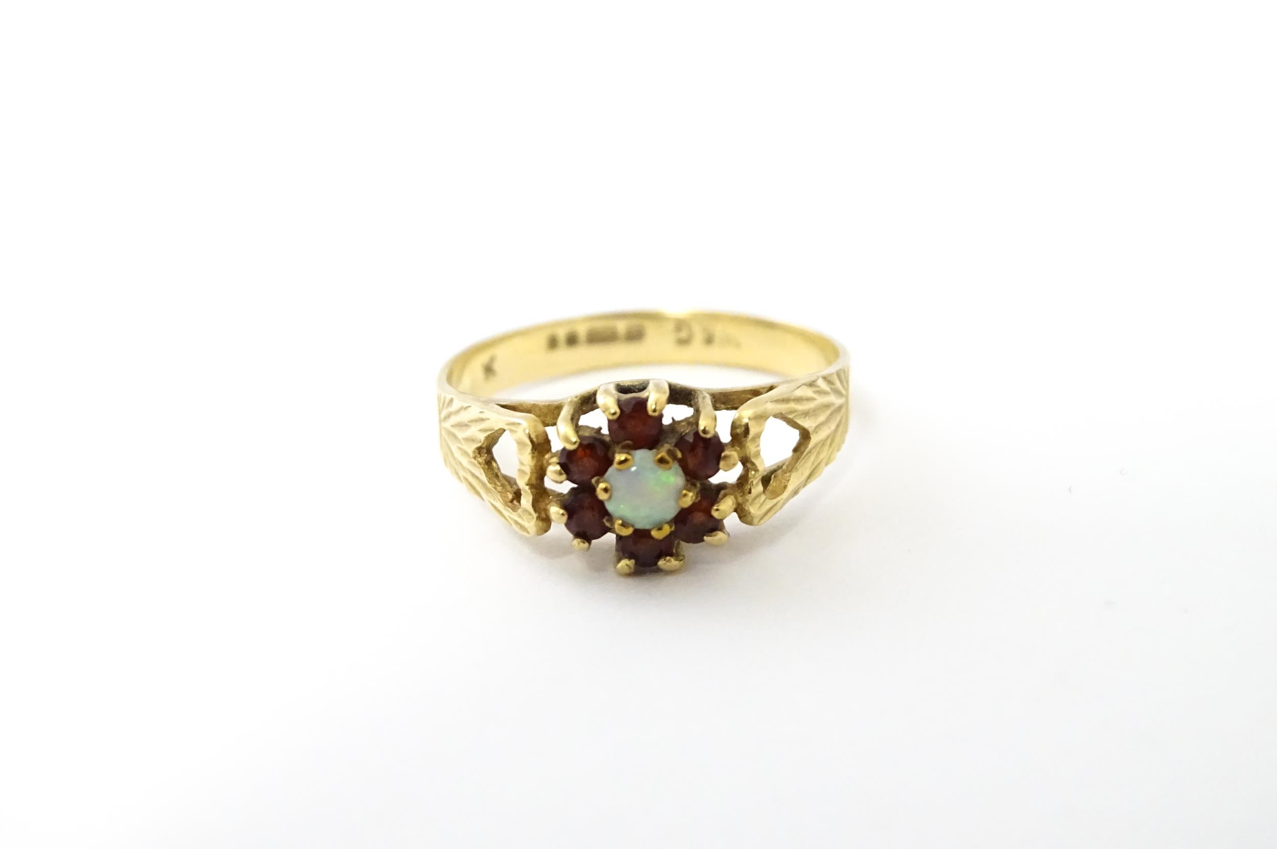 A 9ct gold ring set with central opal bordered by 6 garnets. Ring size approx. L Please Note - we do - Image 2 of 8