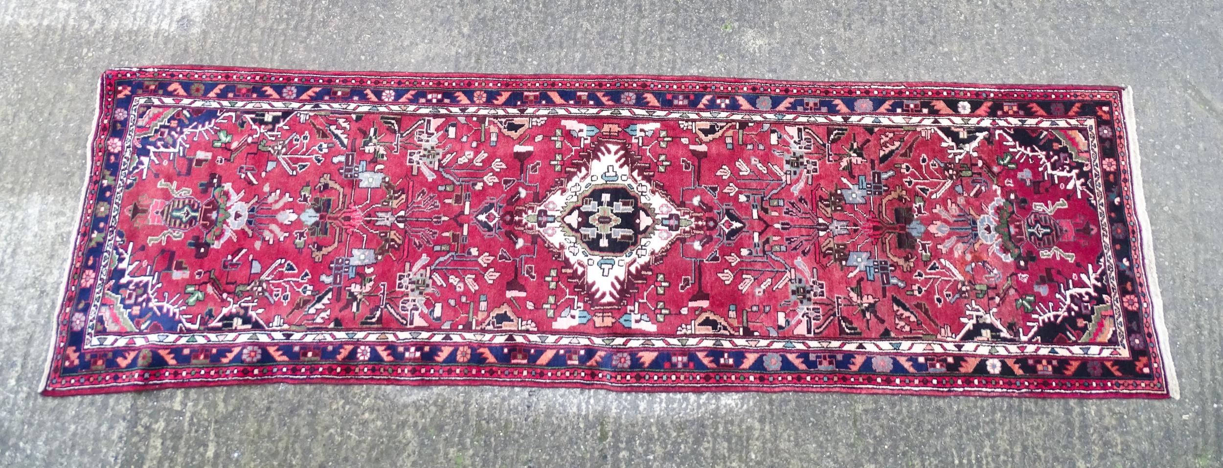 Carpet / Rug : A Persian Hamadan runner, the red ground with central cream ground medallion with