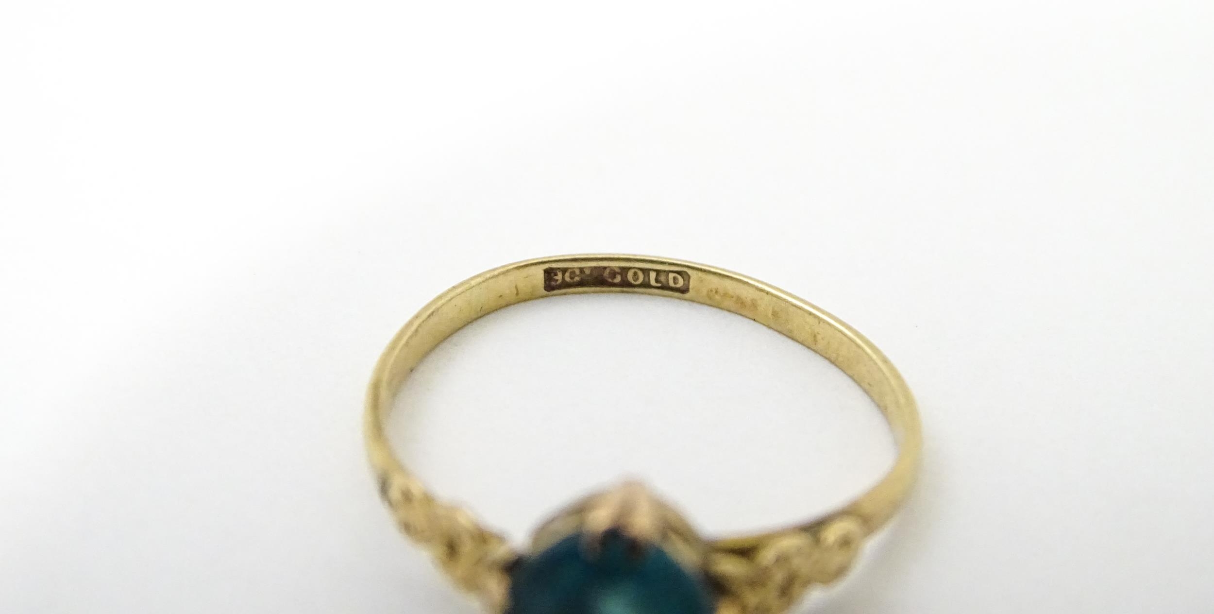 A 9ct gold ring set with aqua coloured glass to centre with engraved detail to shoulders. Ring - Image 2 of 5