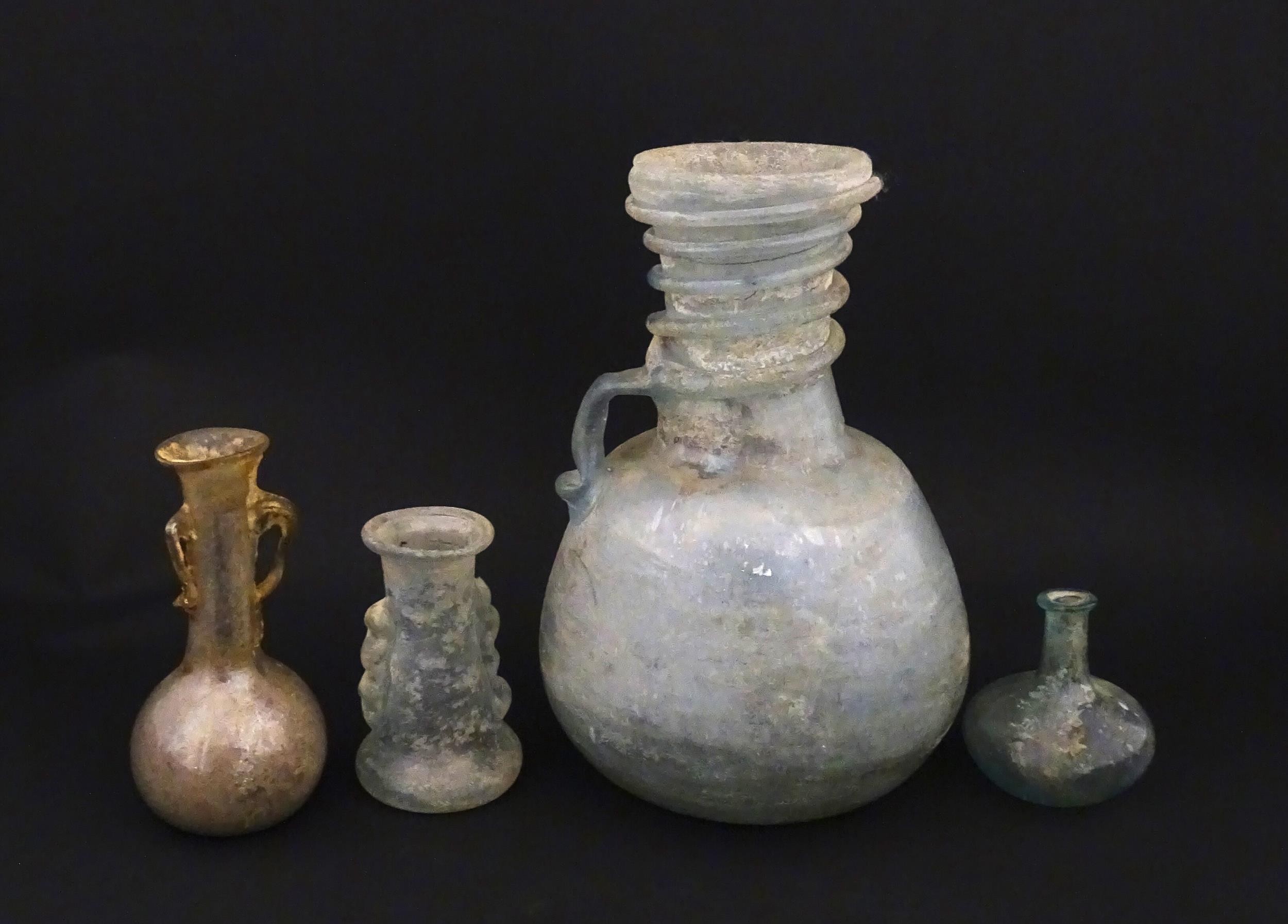 Four glass vases in the Roman style with iridescent finish, some with trail detail. Largest