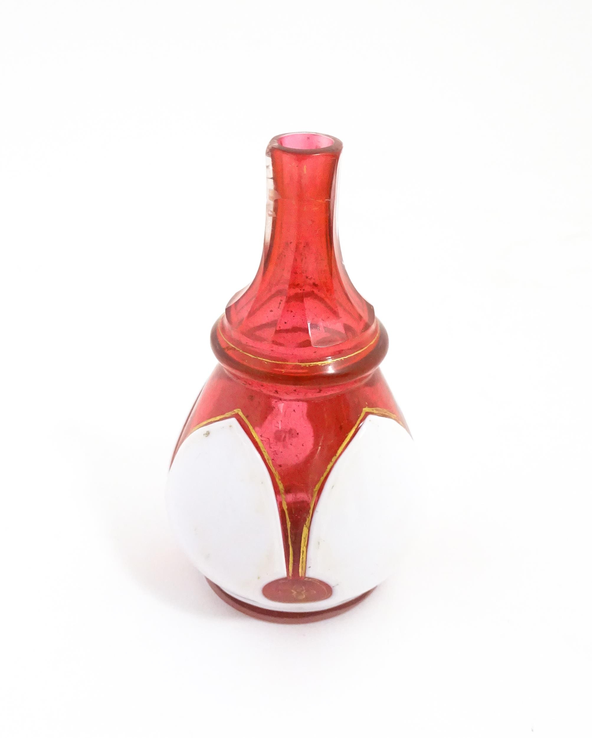 A small Bohemian style red and white glass bottle vase with gilt highlights. Approx. 3 3/4" high - Image 4 of 6