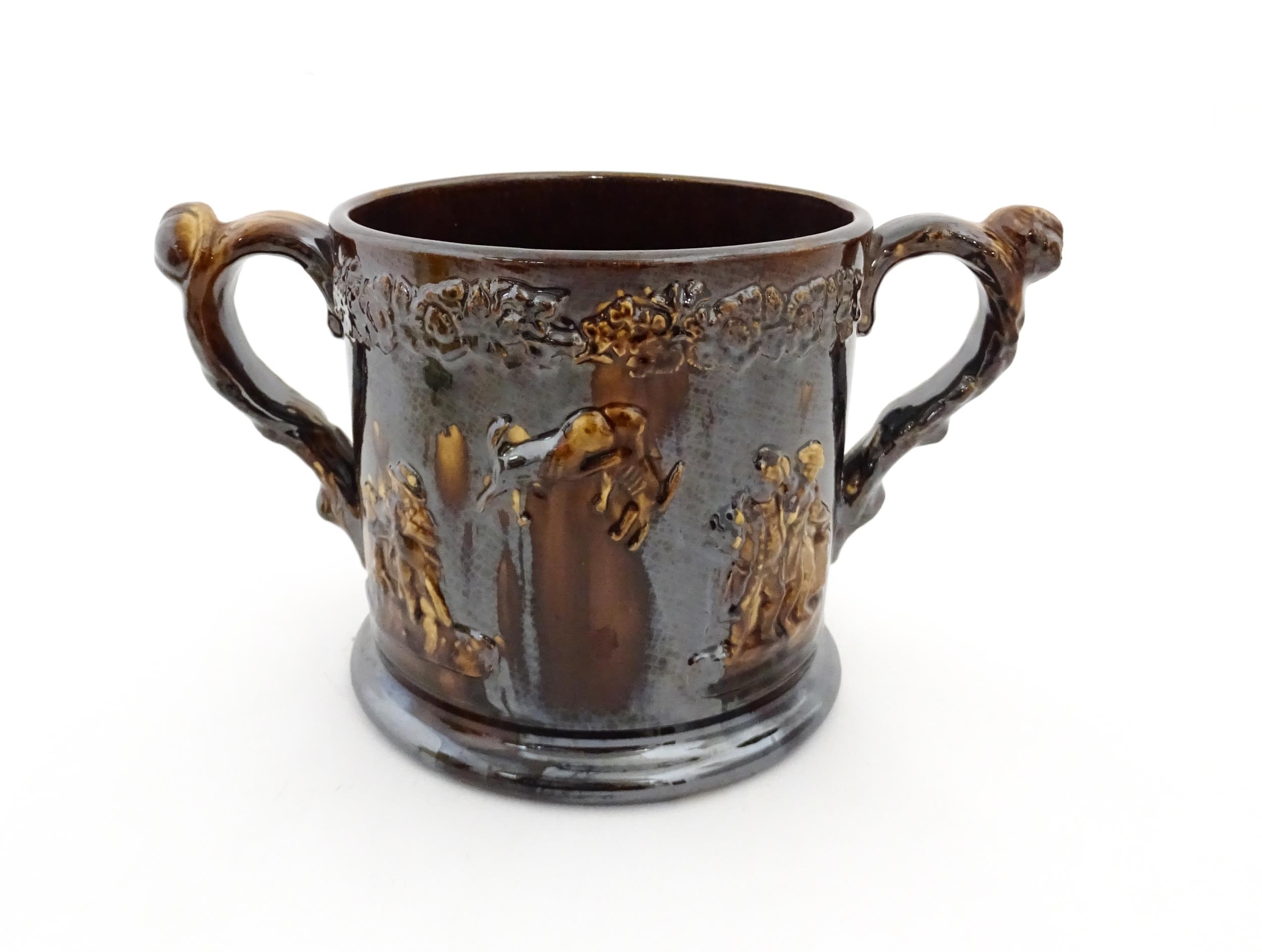 A large Staffordshire treacle glazed frog loving cup decorated in relief with depictions of - Image 4 of 9