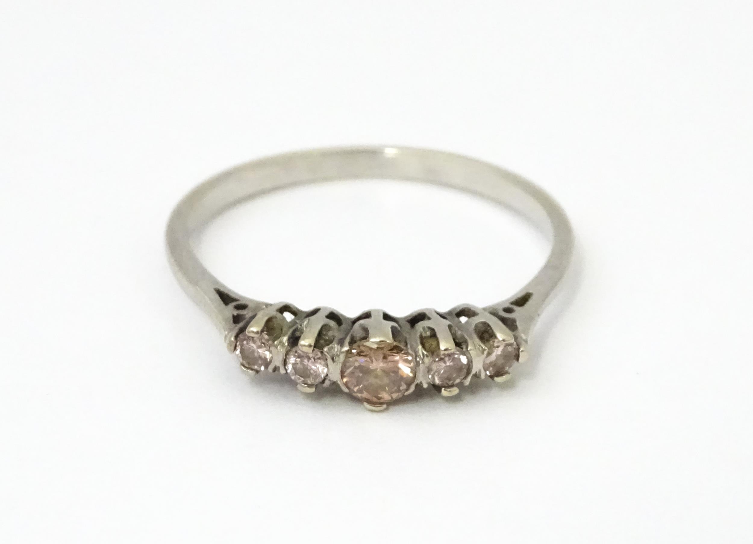 A white gold ring set with central brown diamond flanked by 4 further diamonds in a linear - Image 3 of 7