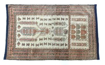 Carpet / Rug: A beige ground rug with repeated motifs worked in salmon pink, brown and beige, with