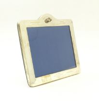 An easel back photograph frame with silver surround with horse head and engraved detail,