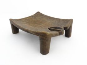 Ethnographic / Native / Tribal: An African carved wooden stool with pierced decoration, raised on