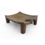 Ethnographic / Native / Tribal: An African carved wooden stool with pierced decoration, raised on