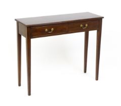 A 20thC mahogany console table / side table with a reeded edge and two short drawers with swan