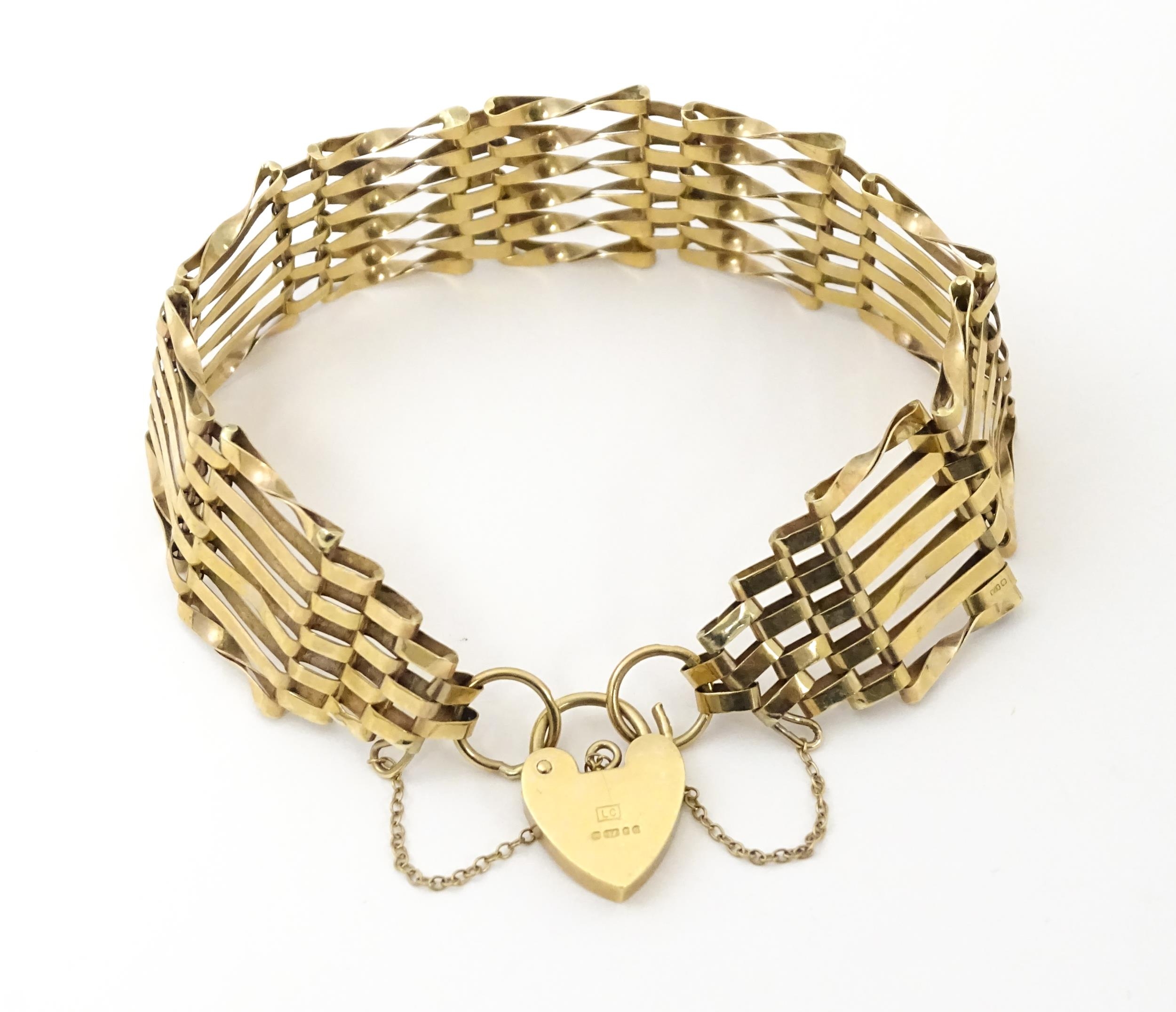 A 9ct gold bracelet with padlock formed clasp. Approx 7 1/2" long x 3/4" wide Please Note - we do