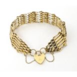 A 9ct gold bracelet with padlock formed clasp. Approx 7 1/2" long x 3/4" wide Please Note - we do