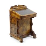 A mid / late 19thC burr walnut Davenport surmounted by a fitted writing box above a leather slope,