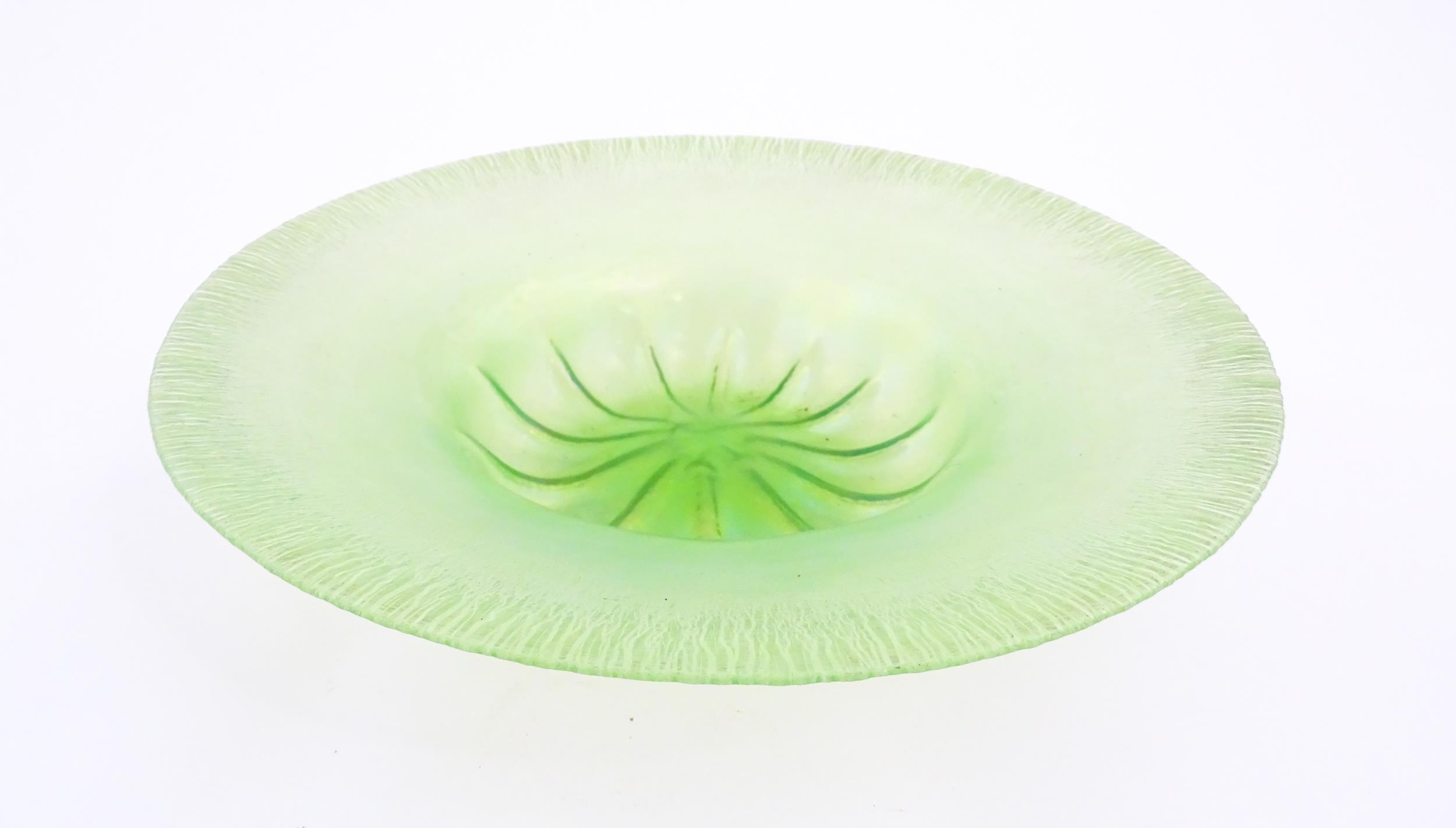 A pale green lustre glass bowl with lobed centre and textured rim. Approx. 12 1/2" diameter Please