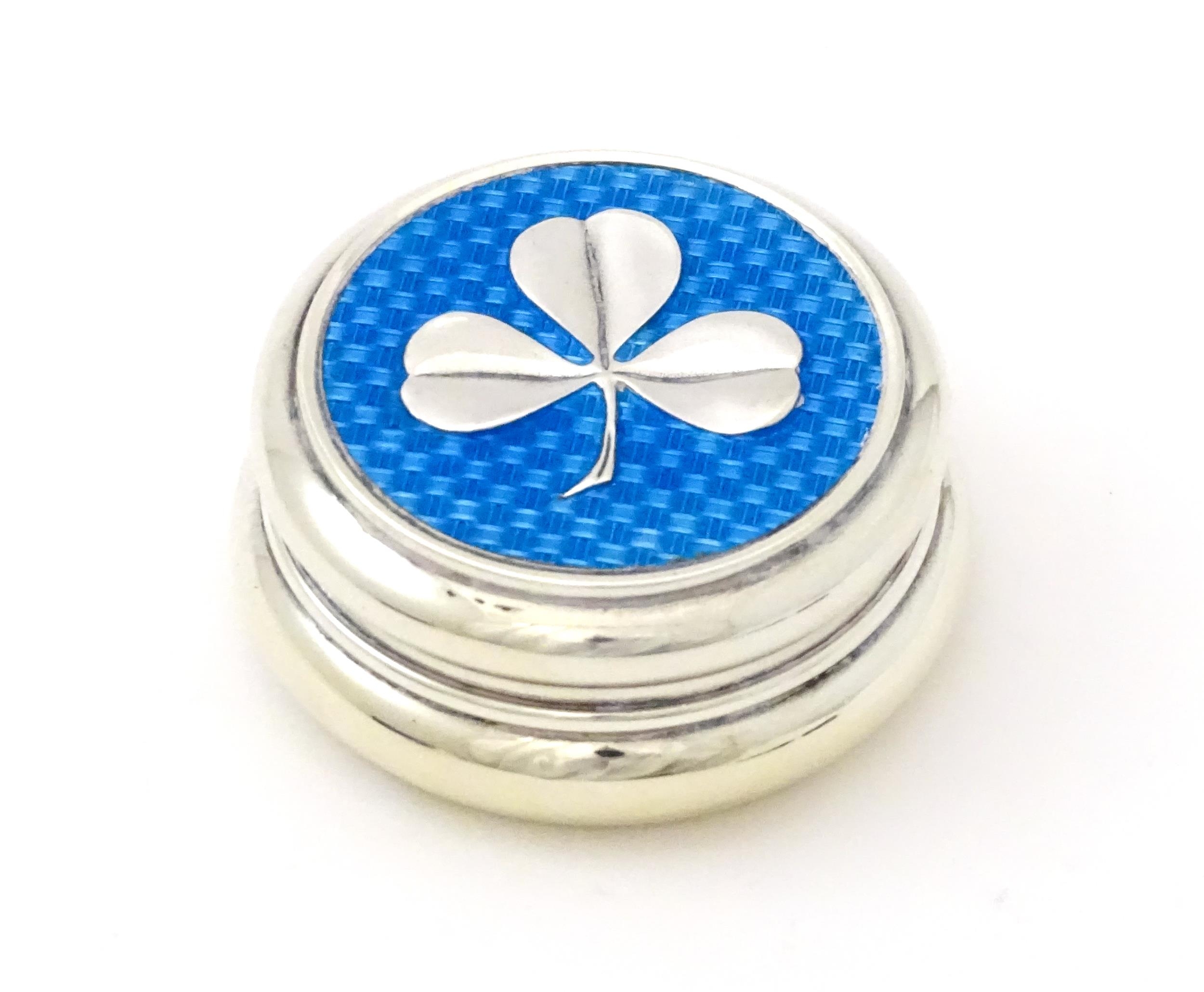 A silver patch / pill box with turquoise guilloche enamel decoration and applied clover detail,