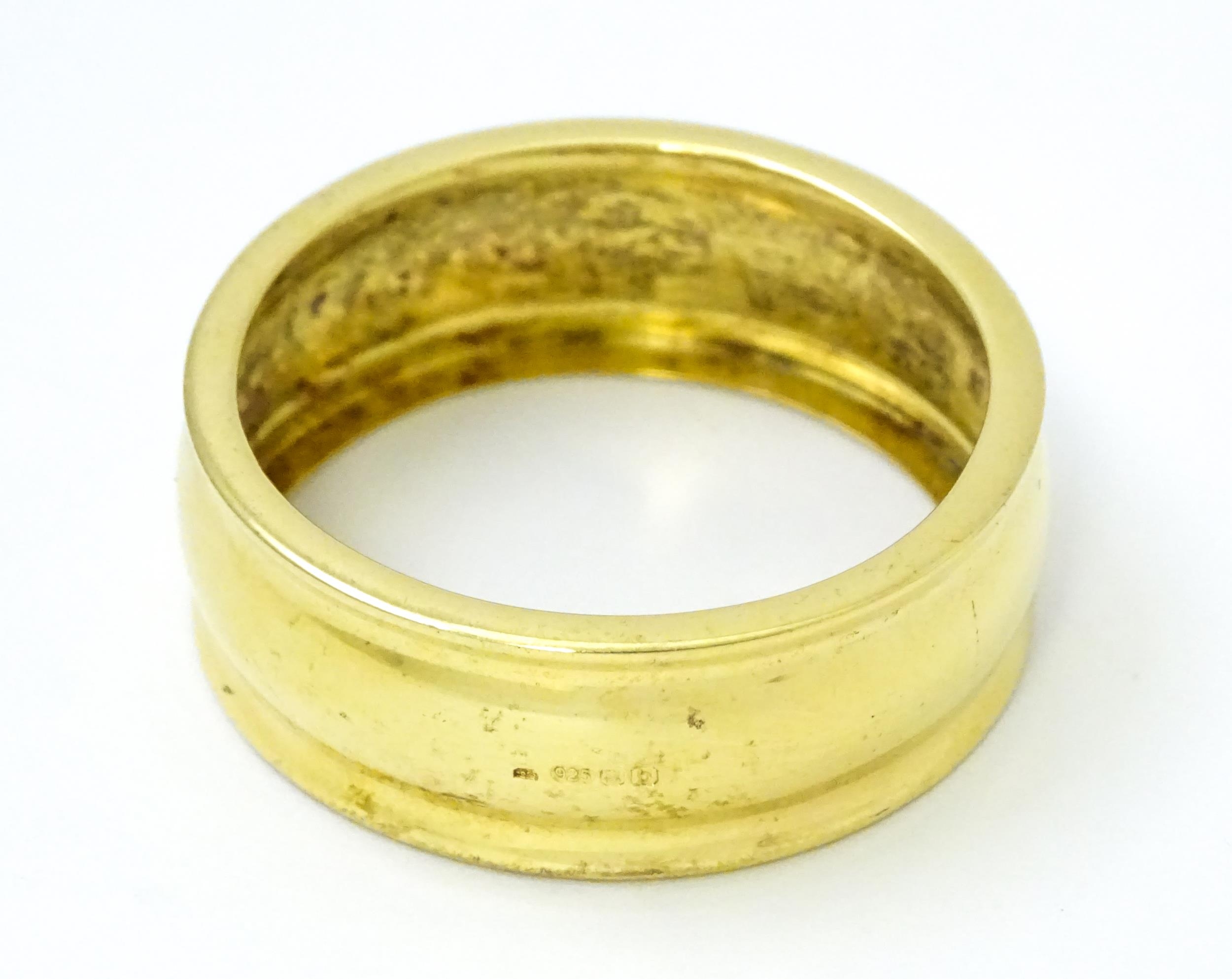 A silver gilt napkin ring hallmarked London 2001, maker Douglas Pell Silverware. 1 1/2" Wide