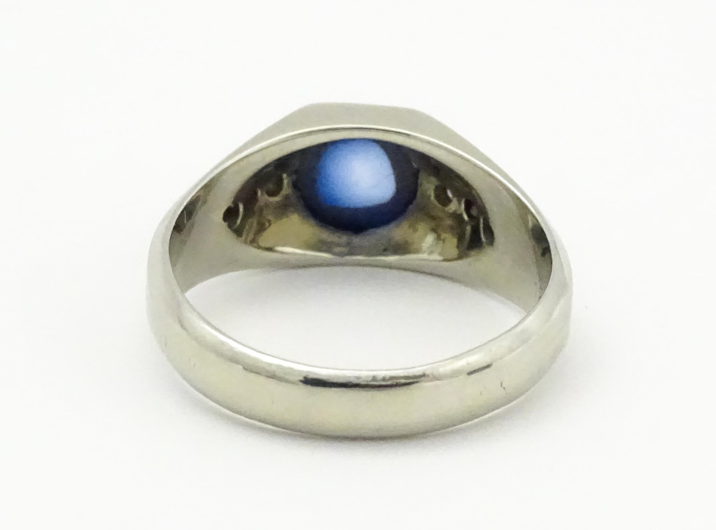 An 18ct white gold ring set with central sapphire cabochon flanked by three diamonds to each - Image 5 of 8