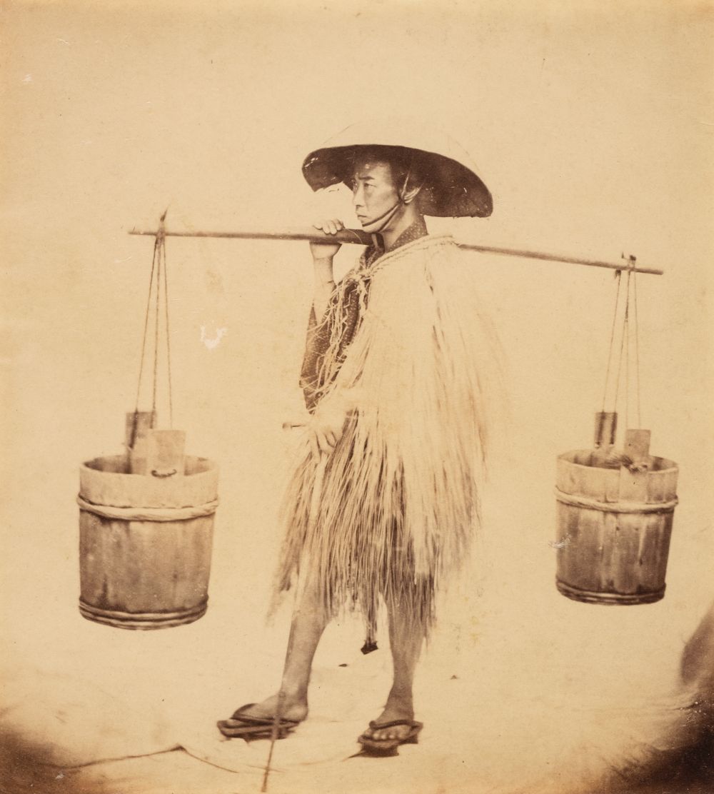 Japan. A Japanese water carrier in a straw raincoat and hat, c. 1865