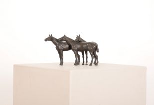 A DARK BROWN PATINATED BRONZE OF THREE BRIDLED HORSES