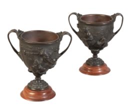 A PAIR OF BRONZE URNS WITH SCROLLED HANDLES