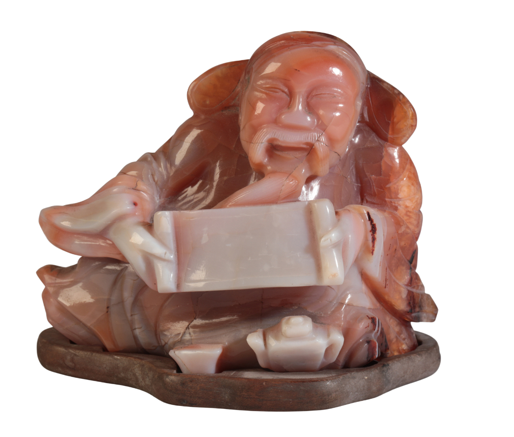 A CHINESE CARVED AGATE FIGURE OF A RECLINING SCRIBE