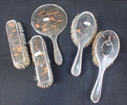 A GEORGE V SILVER AND TORTOISESHELL BACKED FIVE PIECE DRESSING TABLE SET