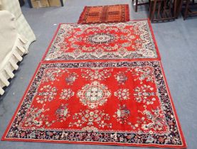 TWO SIMILAR RED GROUND MACHINE MADE RUGS
