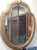 A VICTORIAN SHIELD-SHAPE GILT FRAMED MIRROR