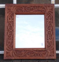 A CARVED OAK ARTS AND CRAFTS STYLE MIRROR